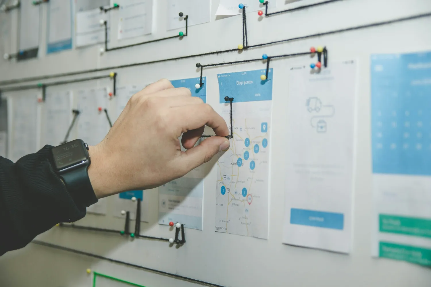 Main organisant des fiches sur un tableau de travail
