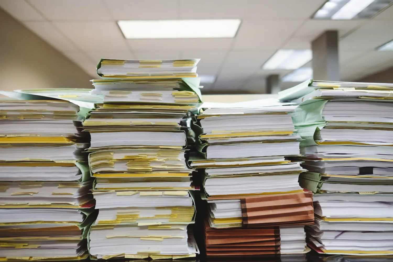 Piles de dossiers papier dans un bureau